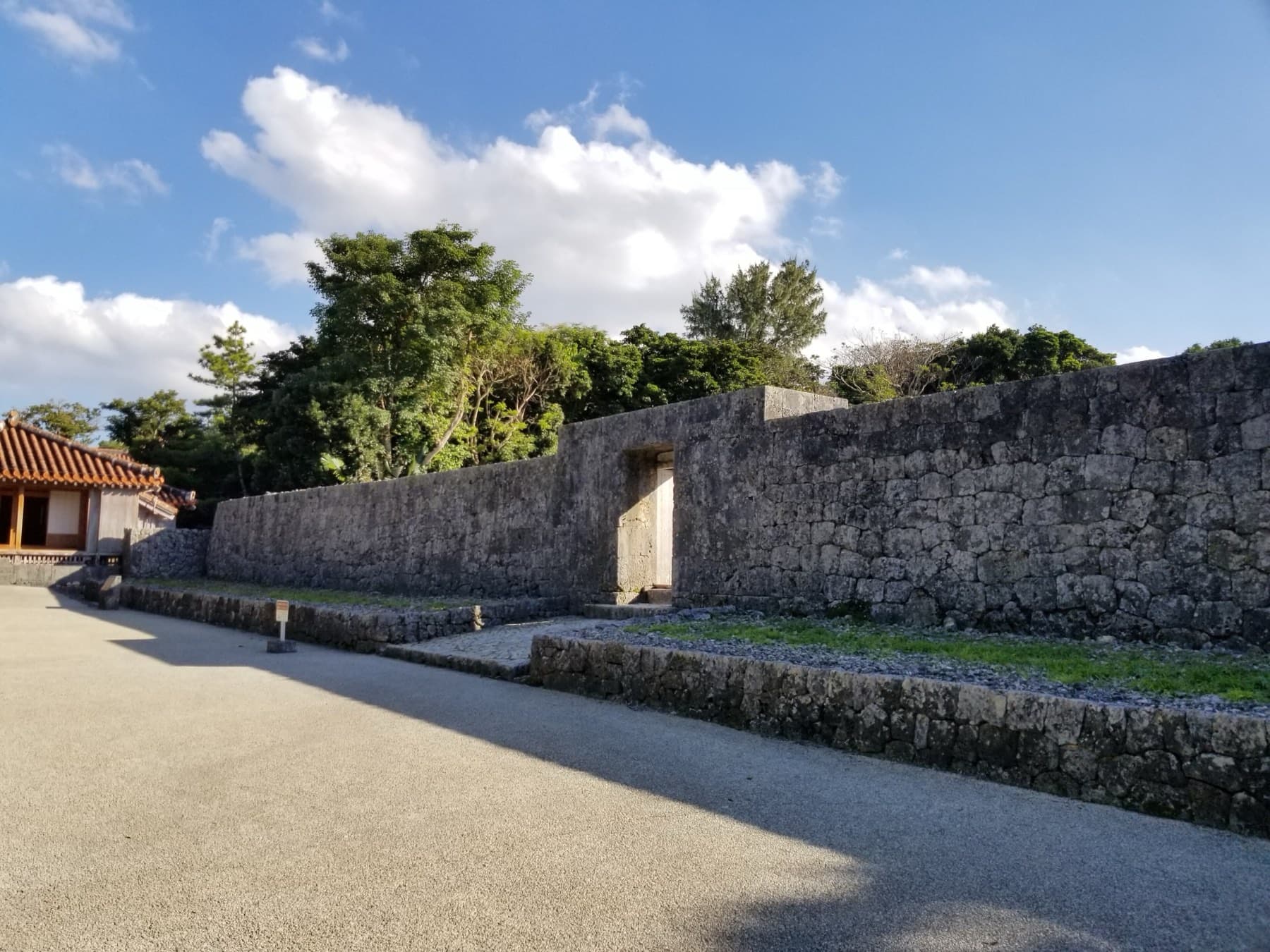Late afternoon sun throws long shadows across the forecourt of Tamaudun toward the first gate in its outer limestone wall